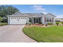 Charming single-story home with manicured lawn, brick driveway, and attached two-car garage at 8980 Se 176Th Limerick Ln, The Villages, FL 32162