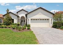 Charming single-story home featuring a manicured lawn, brick driveway, and attached two-car garage at 9307 San Jose Blvd, Howey In The Hills, FL 34737