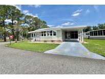 Charming single-story home with a well-manicured lawn and covered parking at 105 Temple W Cv, Leesburg, FL 34748
