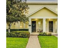 Inviting front entrance featuring a brick walkway, manicured lawn, and cozy seating area at 14421 Vashons Way, Winter Garden, FL 34787