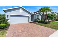 Charming home with brick driveway, well-maintained lawn, and manicured shrubs at 17112 Goldcrest Loop, Clermont, FL 34714