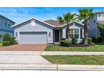 Charming single-story home with a well-manicured lawn and inviting curb appeal with palm trees at 17112 Goldcrest Loop, Clermont, FL 34714