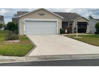 Charming single-story home featuring a spacious driveway, two-car garage, and well-maintained landscaping at 1723 Banberry Run, The Villages, FL 32162