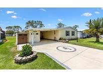 Charming single-story home with a well-manicured lawn and decorative palm tree design on the driveway at 1726 W Schwartz Blvd, Lady Lake, FL 32159