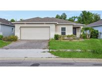 Charming single-story home with a two-car garage and well-maintained front lawn at 185 Hamlet Loop, Davenport, FL 33837