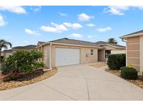 Charming one-story home featuring a two-car garage and a well-maintained front yard at 1963 Ladyfish Ave, The Villages, FL 32162