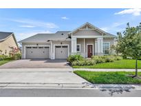 Charming single-story home featuring a three-car garage, well-manicured lawn, and inviting entryway at 2666 Meadowedge Loop, St Cloud, FL 34772