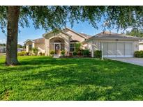 Charming single-story home with a lush green lawn and mature landscaping at 27146 Greenfly Orchid Ln, Leesburg, FL 34748