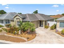 Charming single-story home with mature landscaping, a well-maintained lawn, and a paved driveway at 3074 Eastwood Ter, The Villages, FL 32163