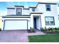 Charming two-story home with a two car garage, landscaped yard, and neutral color palette at 358 Switchgrass Loop, Minneola, FL 34715