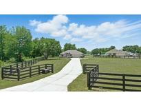 Scenic front exterior with long driveway, fenced yard and plenty of grass at 40143 Babb Rd, Umatilla, FL 32784