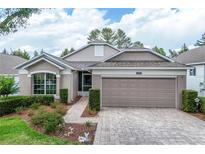 Charming single-story home with a well-manicured lawn, paver driveway, and a two-car garage at 4083 Capland Ave, Clermont, FL 34711