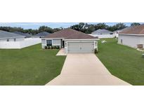 Charming single-story home with a well-manicured lawn and a two-car garage, exuding curb appeal at 5547 Se 91St Pl, Ocala, FL 34480