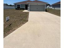 Charming single-story home with a well-maintained lawn and a spacious driveway leading to an attached two-car garage at 5547 Se 91St Pl, Ocala, FL 34480
