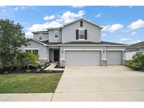 Charming two-story home with a three car garage, manicured landscaping, and a welcoming front entrance at 605 Black Eagle Dr, Groveland, FL 34736