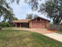 Charming single-story home with a brick driveway and mature trees at 901 Baylor Dr, Deltona, FL 32725