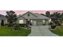 Charming single-story home boasts a well-manicured lawn, mature landscaping, and a three-car garage at 946 Isle Of Palms Path, The Villages, FL 32162