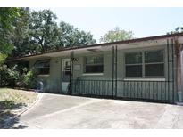 Exterior view of home featuring a covered porch, concrete driveway, and mature trees at 1095 Golden Isle Dr, Mount Dora, FL 32757