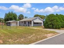 Charming single-story home with well-maintained lawn and detached garage at 1119 Pine Ave, Tavares, FL 32778