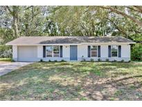 Charming single-story home with a well-maintained front yard, and a driveway leading to an attached garage at 1228 Padgett Cir, Lady Lake, FL 32159