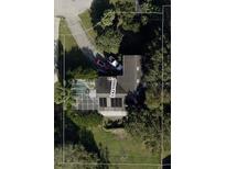 Aerial view of a single-Gathering home, featuring a screened pool, driveway with two cars, and a well-maintained lawn at 12730 Katherine Cir, Clermont, FL 34711