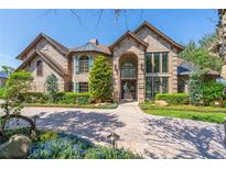 Stunning brick home featuring a well manicured lawn and beautiful landscaping at 1956 Brantley Cir, Clermont, FL 34711