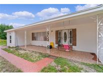 Inviting front porch with unique columns, a swing and a charming brick-paved walkway at 2022 Edgewood Rd, Leesburg, FL 34748