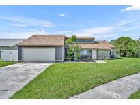 Charming single-Gathering home featuring a two-car garage, well-maintained lawn and beautiful landscaping at 2104 Winding Ridge S Ave, Kissimmee, FL 34741