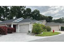Charming single-story home featuring a well-manicured lawn and an attached garage at 2441 Nellie Rd, The Villages, FL 32163