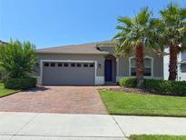Charming single-Gathering home featuring a brick driveway, two-car garage, and lush landscaping at 3181 Hill Point St, Minneola, FL 34715