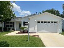 Charming one-story home featuring a two-car garage, well-maintained lawn, and attractive landscaping at 3337 Candlebrook St, The Villages, FL 32162