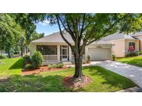 Charming single-story home with a screened porch, attached garage and a landscaped front yard and brick-paved drive at 3607 Fairfield Dr, Clermont, FL 34711