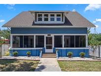Charming blue two-story home with a screened-in front porch and landscaped front yard at 378 W Osceola St, Clermont, FL 34711
