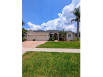Charming single-story home with three-car garage and a well manicured lawn at 3969 Derby Glen Dr, Clermont, FL 34711