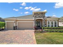 Charming single-story home featuring a two-car garage, stone accents, and well-manicured landscaping at 440 Bellissimo Pl, Howey In The Hills, FL 34737