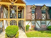 Charming condo with a Tudor-style exterior, lush landscaping, and covered entryway at 500 Newell Hill Rd # 113D, Leesburg, FL 34748