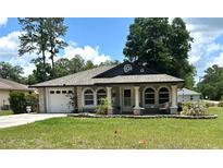 Charming single-story home with well-manicured lawn and inviting front porch at 5051 Nw 61St Ct, Ocala, FL 34482