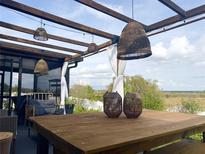 Inviting covered patio featuring stylish wicker lighting and a rustic wooden table, perfect for outdoor relaxation with picturesque views at 591 Black Eagle Dr, Groveland, FL 34736