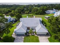 A beautiful aerial view of a single-Gathering home with lush landscaping and a sprawling green lawn at 6048 Topsail Rd, Lady Lake, FL 32159