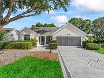 Charming single-story home with a well-manicured lawn, decorative driveway, and inviting facade at 628 San Pedro Dr, The Villages, FL 32159