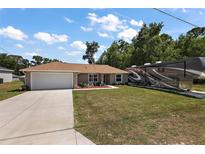 Charming single-story home with a well-manicured lawn and spacious driveway, plus RV parking at 7162 Se 124Th St, Belleview, FL 34420