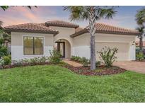 Charming single-story home boasts a tile roof, manicured lawn, and lush landscaping at 9220 San Jose Blvd, Howey In The Hills, FL 34737