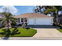 Charming single-story home featuring a manicured lawn and a spacious three-car garage at 9430 Se 176Th Saffold St, The Villages, FL 32162