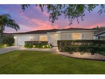 Charming single-story home with meticulously landscaped front yard and cozy lighting at 1014 Nash Loop, The Villages, FL 32162