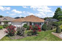 Charming home featuring manicured landscaping, colorful flowerbeds, and a well-maintained lawn at 1175 Johnston Path, The Villages, FL 32162