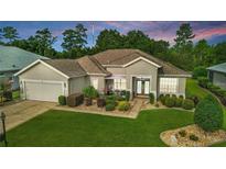 Charming single-story home boasts lush landscaping, inviting front porch, and well-manicured lawn at 11868 Se 91St Cir, Summerfield, FL 34491