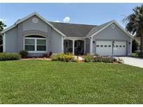 Charming single-story home with well-maintained lawn and colorful flower beds at 1512 Nueva Pl, The Villages, FL 32159