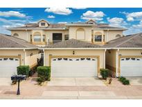 Charming townhome featuring a well-manicured lawn and a two-car garage, all under a bright blue sky at 17406 Chateau Pine Way, Clermont, FL 34711