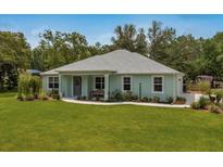 Charming single-story home with a well-manicured lawn, lush landscaping, and inviting curb appeal at 2163 County Road 243F, Wildwood, FL 34785