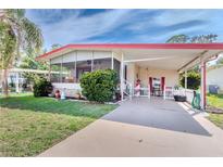 Charming single-story home with a welcoming screened-in porch and covered carport with picket fence at 2475 Karen Dr, Mount Dora, FL 32757